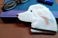 Smudge dog waiting to be used as a bookmark next to a book with glasses