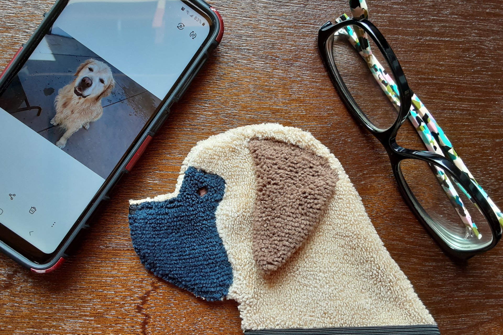 Smudge Dog shown with phone and glasses. Two of the items it can clean.