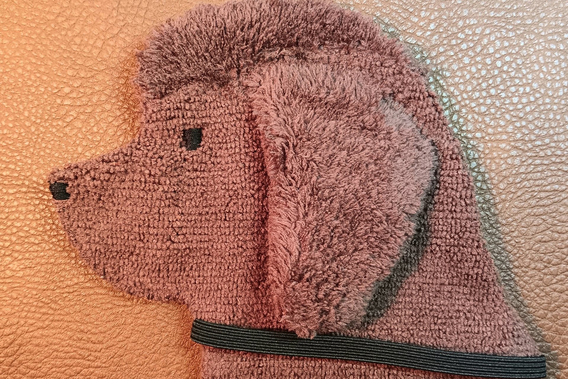 Soft, microfiber terry cloth towels cut, sewn, and made in the shape of the head of a brown Newfoundland. Little larger than palm sized. Texture of the Smudge Dog is perfect for cleaning cell phone screens, musical instruments, glasses, etc.